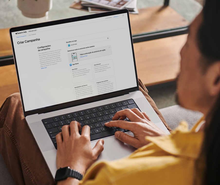Uma pessoa usando um MacBook para criar uma nova campanha no Apple Ads.