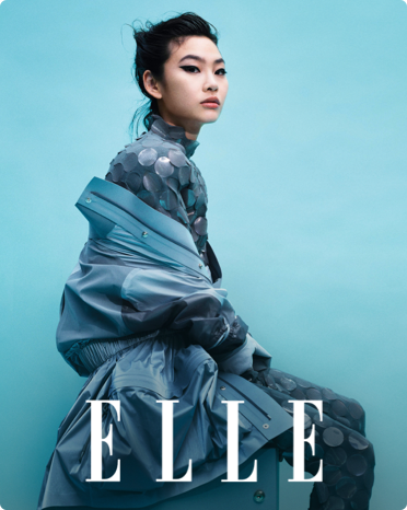 Обложка журнала Elle с моделью в синем брючном костюме и пальто от кутюр.