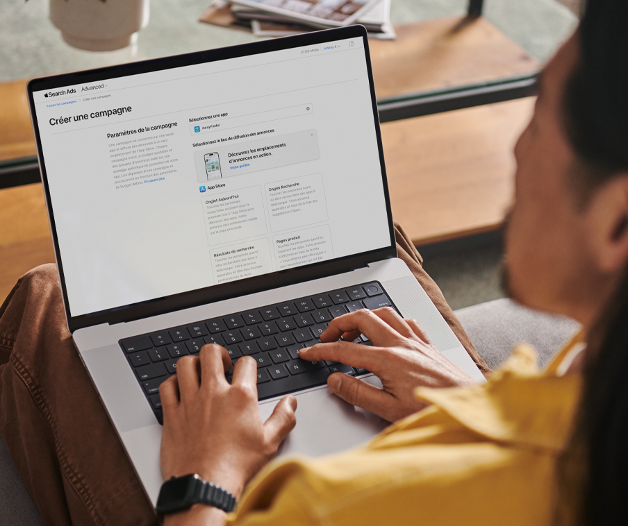 Une personne travaillant sur un MacBook à la création d’une campagne dans Apple Search Ads.