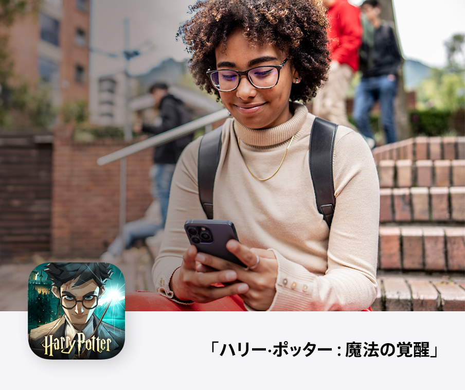 iPhoneでゲームをプレイしながら笑っている人。