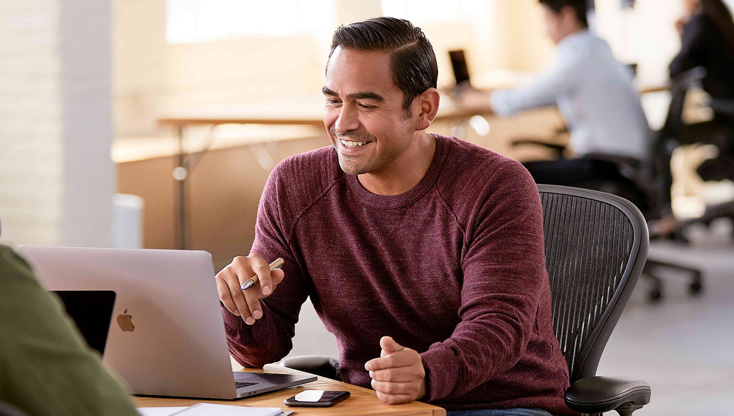 A team of two people working together at a desk.