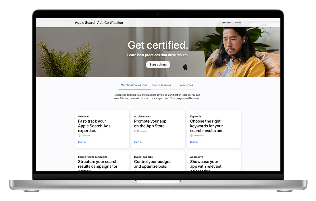 A MacBook showing the Apple Search Ads Certification home page.